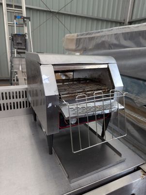 un grille-pain posé sur un tapis roulant
