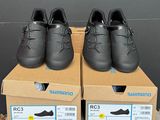 deux paires de chaussures noires sont posées sur des cartons