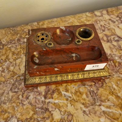 un bureau en bois avec un plateau en marbre sur lequel est posée une plaque en laiton