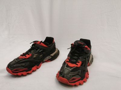 une paire de baskets noires et rouges avec des lacets rouges