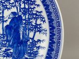 a blue and white plate with a picture of a man and a woman