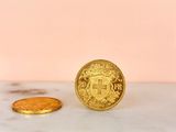 a gold coin sitting on top of a marble counter next to a gold coin