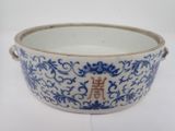 un vieux bol bleu et blanc sur lequel figure une inscription en chinois