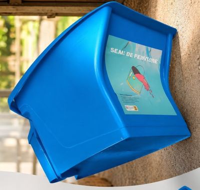 une boîte en plastique bleue accrochée au mur d'un immeuble