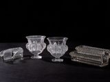 trois vases en cristal et une boîte posés sur une surface noire