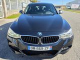 the front of a black bmw car parked on the side of the road
