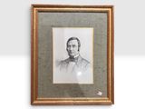 portrait d'un homme en costume-cravate dans un cadre doré