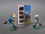 two figurines of a man with a sword and a book