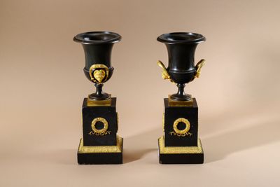 pair of black and gold vases sitting on top of each other