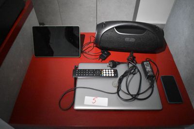 un ordinateur portable et un téléphone portable posés sur une table rouge