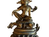 a bronze statue of a woman sitting on top of a snake