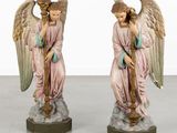 two figurines of angels are sitting on a pedestal