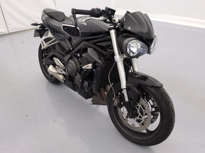 une moto noire garée dans une pièce aux murs blancs