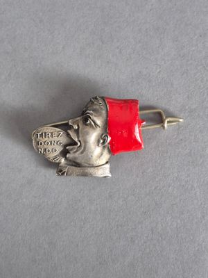 une épingle en argent surmontée d'un chapeau rouge