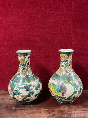 two vases sitting on a table with a red background
