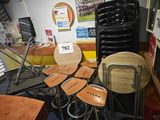 de nombreuses chaises et tabourets dans une pièce où est accrochée une affiche au mur