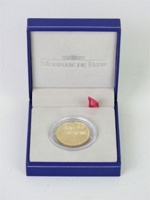 l'image d'une pièce d'or dans une boîte bleue posée sur une surface blanche