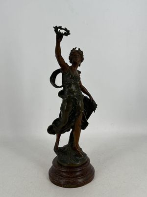 une statue en bronze représentant une femme tenant un oiseau dans la main