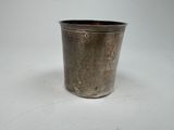 a small metal cup that is sitting on a table