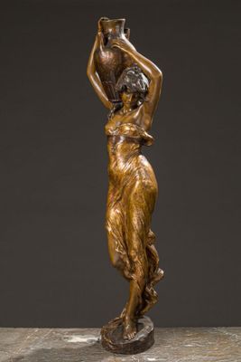 a bronze statue of a woman carrying a pot on her head