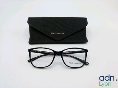 des lunettes noires et un étui noir posés sur une surface blanche
