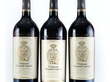 three bottles of wine are lined up on a white surface