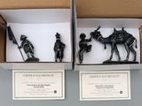 two black figurines in a cardboard box on a table