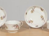 three cups and saucers sitting on a wooden table