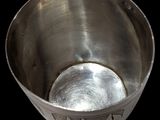 a metal bowl that has a metal spoon inside of it