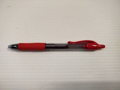 un stylo rouge posé sur une table blanche