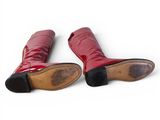 pair of red leather boots on a white surface with a white background