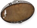 an oval metal tray with a decorative design on it