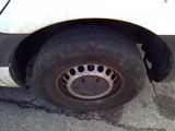 a white van with a flat tire on the street