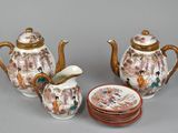 three pieces of porcelain teapots and a plate on the table