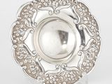 une assiette en argent antique avec un motif décoratif sur le bord