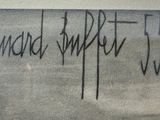 graffiti on the wall of a bathroom with a toilet and a sink