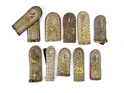 six paires d'insignes militaires portant des numéros, sur un fond blanc