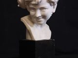 a white marble bust of a woman with a turban on her head