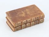 three old books stacked on top of each other on a white surface