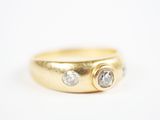 gros plan d'une bague en or ornée de deux diamants