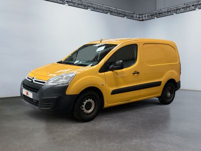 La camionnette jaune est garée dans une grande pièce aux murs blancs.