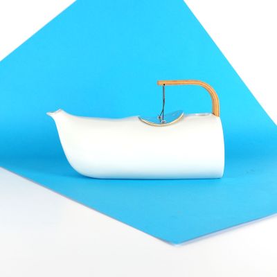 un petit bateau blanc muni d'une poignée en bois sur un fond bleu