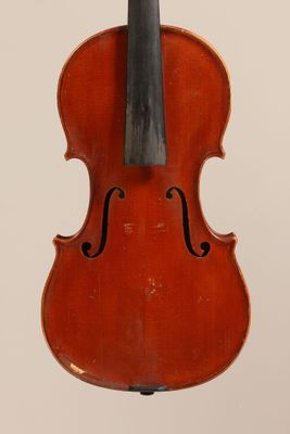 an old violin sitting on top of a wooden stand