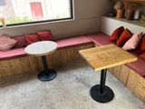 a small table with red pillows on it in the corner of a room