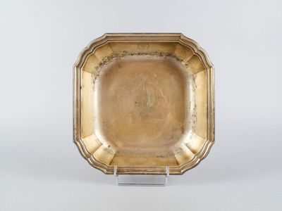 une image représentant une assiette en or posée sur un socle, sur fond blanc
