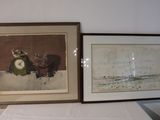 two framed pictures on a table with a clock on it