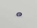 a blue sapphire stone on a white surface