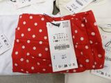 a red and white polka dot bag sitting on a bed
