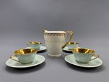 a set of four cups and saucers with gold rims