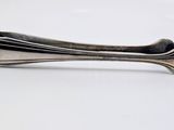 a silver spoon that is sitting on a white surface